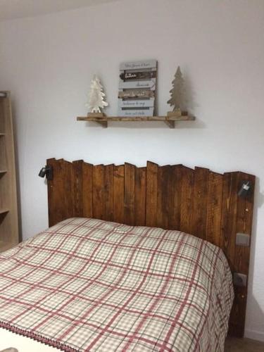 - une chambre avec un lit doté d'une tête de lit en bois et d'étagères dans l'établissement Appart T2 cabine grande terrasse classé 2 *, aux Angles