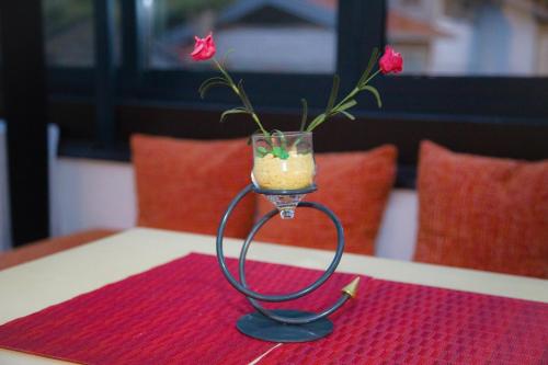 a glass vase with a flower in it on a table at Villa Deny Mostar - with free parking in Mostar
