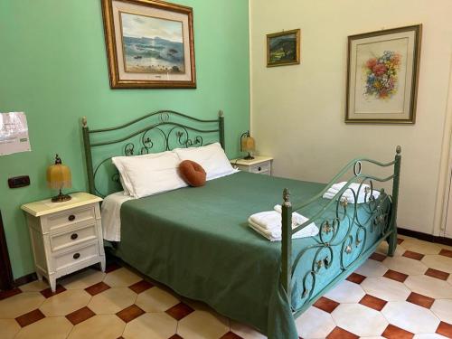ポルティチにあるB&B Il Nidoのベッドルーム1室(緑のベッド1台、ナイトスタンド2台付)