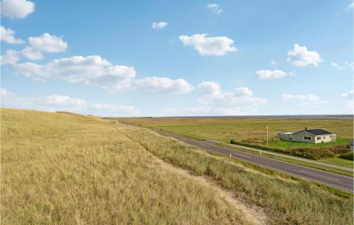 a road in the middle of a field with a house at Nice Home In Ulfborg With Wifi in Ulfborg