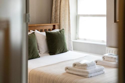 a bedroom with a bed with towels on it at The Georgian House in Alderney