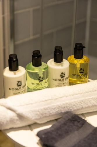 four bottles of toiletries sitting on a towel at The Georgian House in Alderney