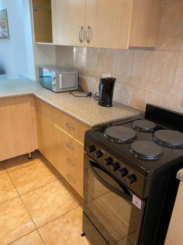 a kitchen with a stove and a microwave at AFYZ Mansions in Lenasia