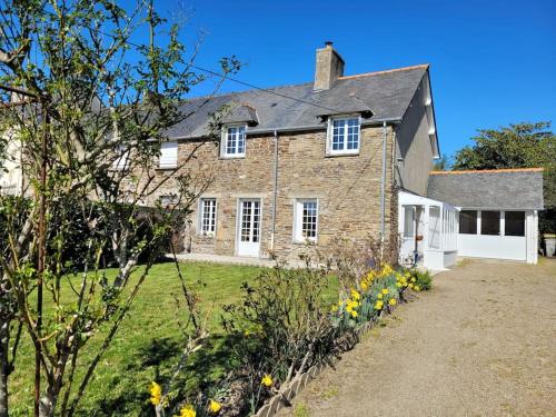 a large brick house with a grass yard at Maison au calme à 2 pas du port in Cancale