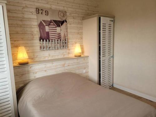ein Schlafzimmer mit einem Bett und zwei Lampen an der Wand in der Unterkunft Maison au calme à 2 pas du port in Cancale