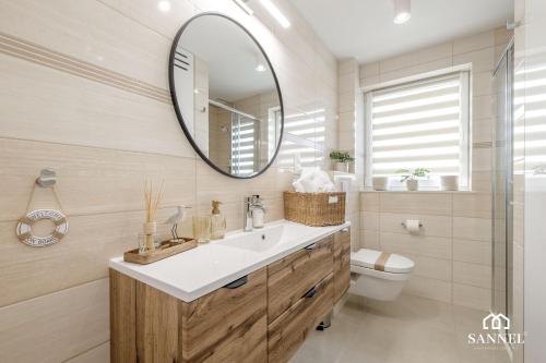 a bathroom with a sink and a mirror at Apartament Elegance - Pobierowo Baltic Apartments in Pobierowo
