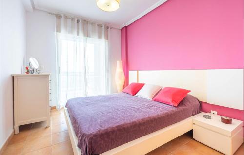 Un dormitorio con una pared rosa y una cama en Lovely Apartment In Campello With Kitchen en Aigues