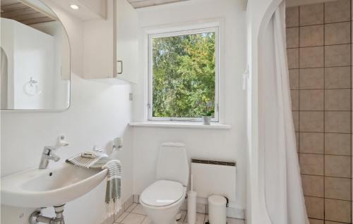 La salle de bains est pourvue de toilettes, d'un lavabo et d'une fenêtre. dans l'établissement Cozy Home In Sams With Kitchen, à Nordby