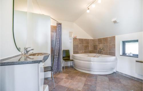 a large bathroom with a large tub and a sink at Awesome Home In Glesborg With 3 Bedrooms And Wifi in Bønnerup