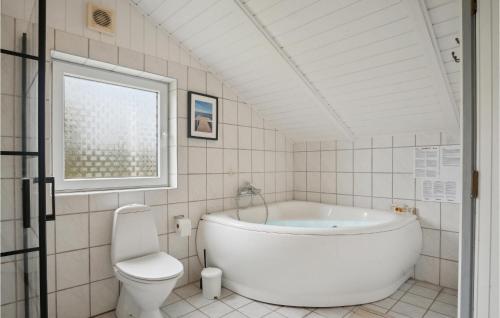 uma casa de banho branca com uma banheira e um WC em Cozy Home In Hejls With Kitchen em Hejls
