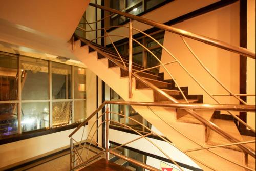 una escalera de caracol de metal en un edificio con ventana en Hotel Sandalwood Inn, en Bangalore