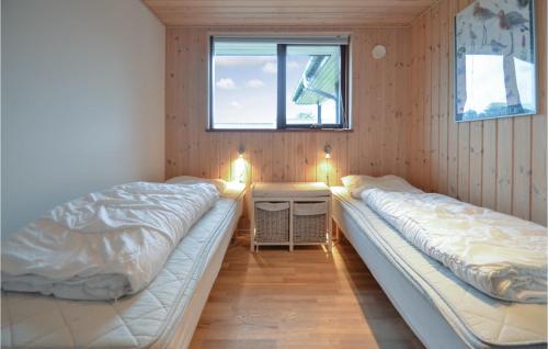 RøndeにあるAwesome Home In Rnde With 3 Bedrooms, Sauna And Wifiのベッド2台、テーブル、窓が備わる客室です。