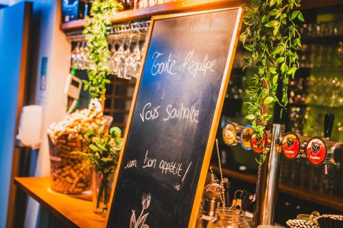 a chalkboard sign in front of a bar at Utopia Hotel - Art & Nature Hotel in Mons