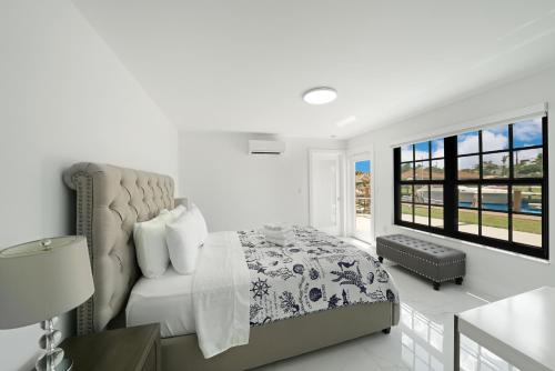 um quarto branco com uma cama e uma cadeira em Dania Beach Unit 1 By Pmi em Dania Beach