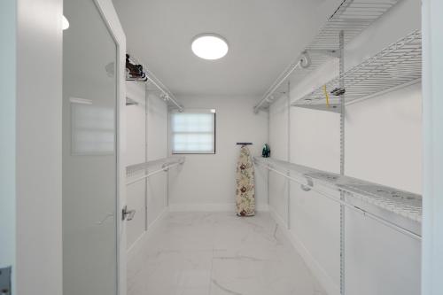 a room with white walls and a hallway with white shelves at Dania Beach Unit 1 By Pmi in Dania Beach