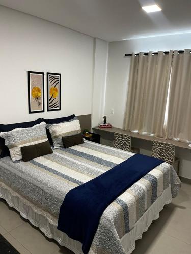 a bedroom with a large bed with a blue blanket at Studio no West Fit Mossoró Nova Betania in Mossoró
