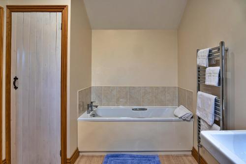 a bathroom with a white tub and a sink at Finest Retreats - The Shippon at Lestitha in Liskeard