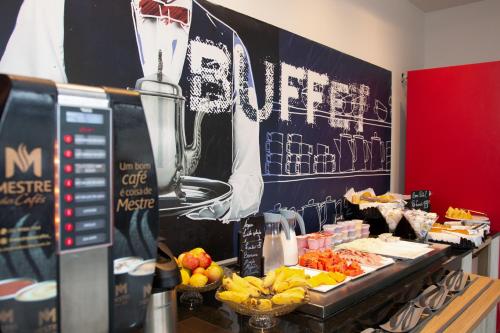 a buffet with fruit and a trophy on the wall at ibis budget Manhuaçu in Manhuaçu