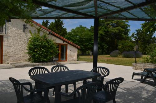 a black table and chairs under an umbrella at Gîte Gers La Métairie in Cézan