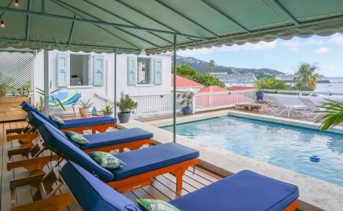a patio with chairs and a swimming pool at At Home in the Tropics in Charlotte Amalie