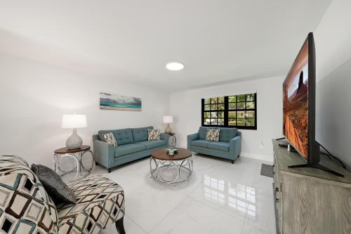 a living room with two blue couches and a flat screen tv at Dania Beach Unit 1 By Pmi in Dania Beach