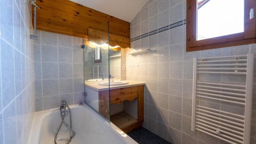 La salle de bains est pourvue d'une baignoire et d'un lavabo. dans l'établissement La Turra 611 - Appt lumineux 8 pers, à Modane