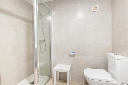 een witte badkamer met een douche en een toilet bij Santa Margarita Deluxe 14-C Levante Beach in Benidorm