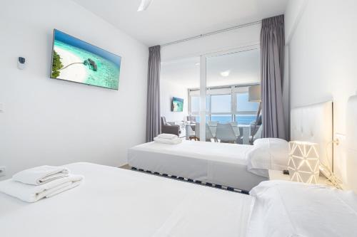 een hotelkamer met 2 bedden en uitzicht op de oceaan bij Santa Margarita Deluxe 14-C Levante Beach in Benidorm