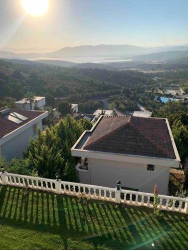 una casa en una colina con el sol en el fondo en Villa Adalin, en Milas