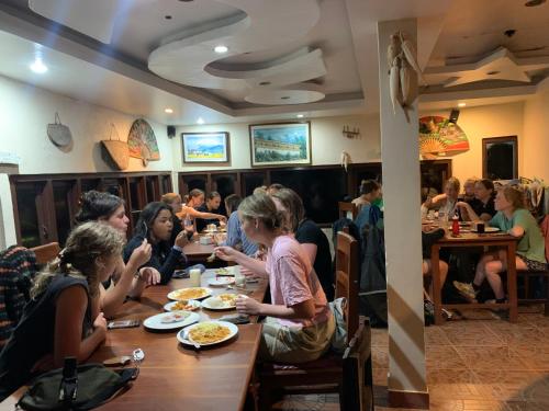 a group of people sitting at a table in a restaurant at Superview Lodge Sarangkot in Pokhara