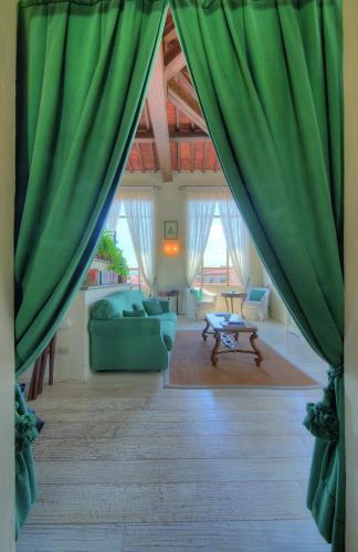 a living room with green curtains and a couch at Palazzo Niccolini al Duomo Residenza D'Epoca in Florence