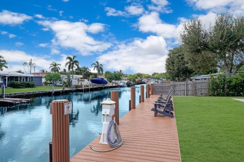 a wooden walkway next to a river with a boat on it at Dania Beach Unit 1 By Pmi in Dania Beach