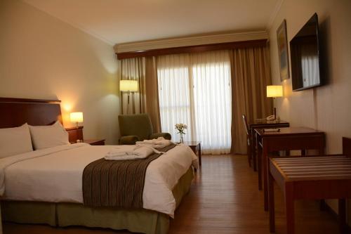 a hotel room with a bed and a desk at Sol Victoria Hotel SPA & Casino in Victoria