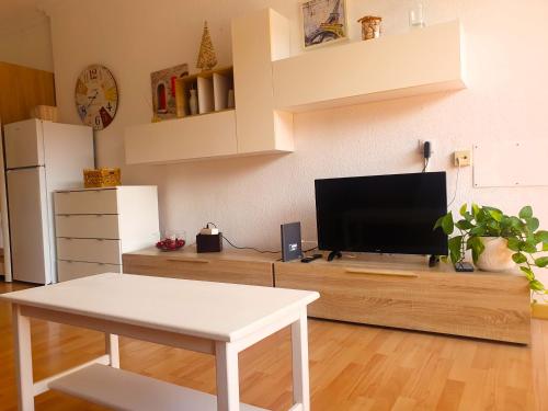 a living room with a tv and a table at Palmera del Mar in Puerto de la Cruz