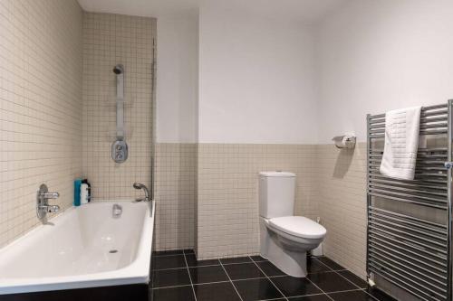 a bathroom with a toilet and a tub and a sink at Central 2 Bed Pavilion Apartment in Brighton & Hove