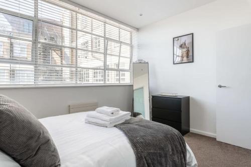 1 dormitorio con 1 cama con sábanas blancas y ventana en Central 2 Bed Pavilion Apartment en Brighton & Hove