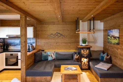 ein Wohnzimmer mit einem Sofa und einem Tisch in der Unterkunft Chalet Heidi in Kartitsch