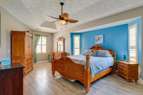 a bedroom with a wooden bed and blue walls at Fort Pierce Escape Beach-Entry Pool, Waterslide! in Fort Pierce