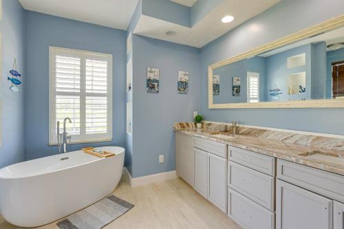 a bathroom with a tub and two sinks and a window at Fort Pierce Escape Beach-Entry Pool, Waterslide! in Fort Pierce