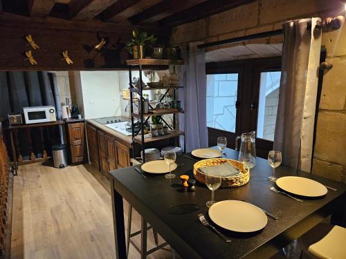 a kitchen with a table with plates and wine glasses at Hotel Robin Quantin in the heart of Old Tours in Tours