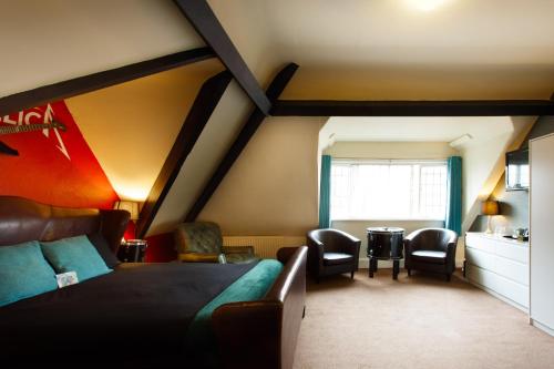 a bedroom with a bed and chairs in a room at The Saddle Inn in Chester