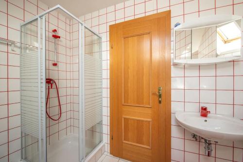 a bathroom with a shower and a sink and a mirror at Ferienhaus Englacher in Ebensee