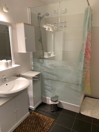 baño blanco con ducha y lavamanos en 4* + 5* Luxury Apartments, en Sankt Gilgen