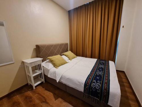 a small bedroom with a bed and a night stand at Lovely VivaMall City View with 2 Card LV11C in Kuching