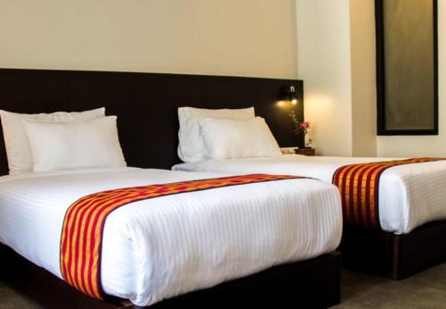 2 letti posti uno accanto all'altro in una camera da letto di Hotel Bhutan Ga Me Ga a Phuntsholing