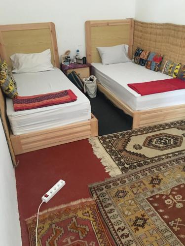 duas camas num quarto com um controlo remoto no chão em Kasba de l'artiste em Mirleft