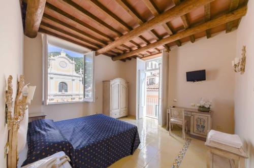 a bedroom with a blue bed and a window at Villa Isabella in Minori