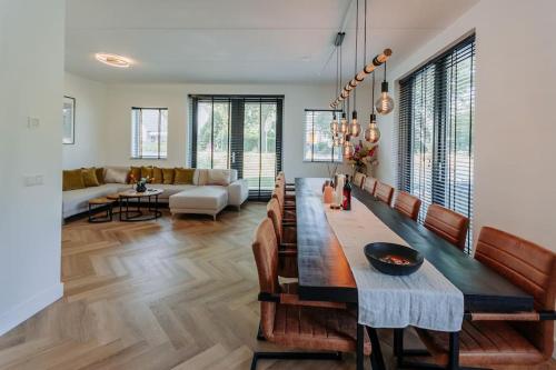Brand new luxurious 6 bedroom villa in Amsterdam في أمستردام: غرفة معيشة مع طاولة وأريكة