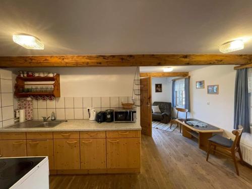 eine Küche mit Holzschränken und ein Wohnzimmer in der Unterkunft Apartments im Almhaus Bachler in Gundisch