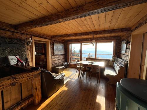 a living room with a table and a large window at Apartments im Almhaus Bachler in Gundisch